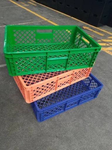Green, peach and blue ventilated plastic crates stacked one above another